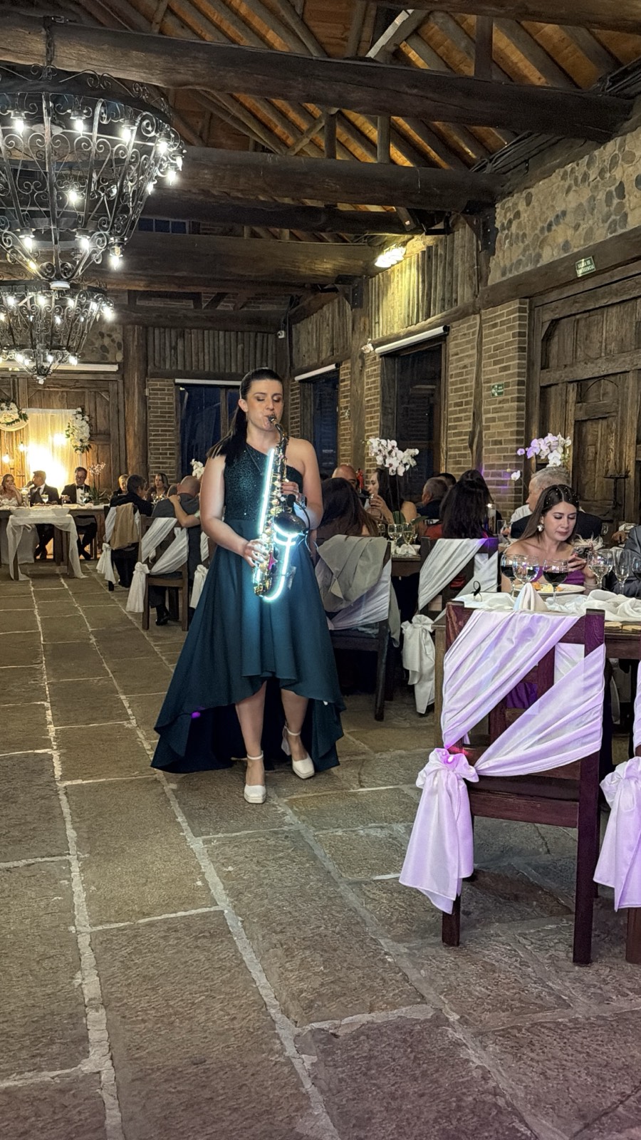 Saxofonista recorriendo el salón entre las mesas durante una recepción de boda en el Bronx